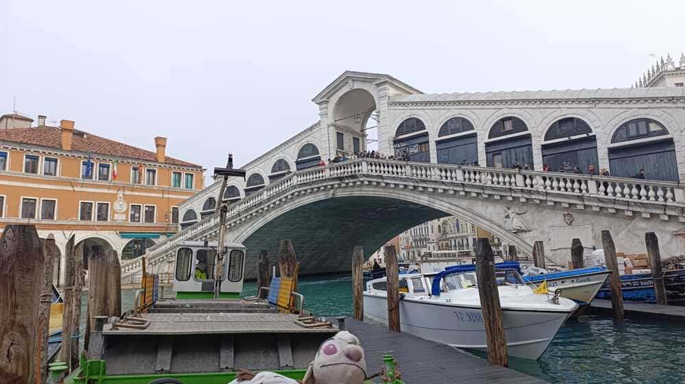 View of the Grand Canal in Venice from a low angle near the water, with boats and historic buildings.